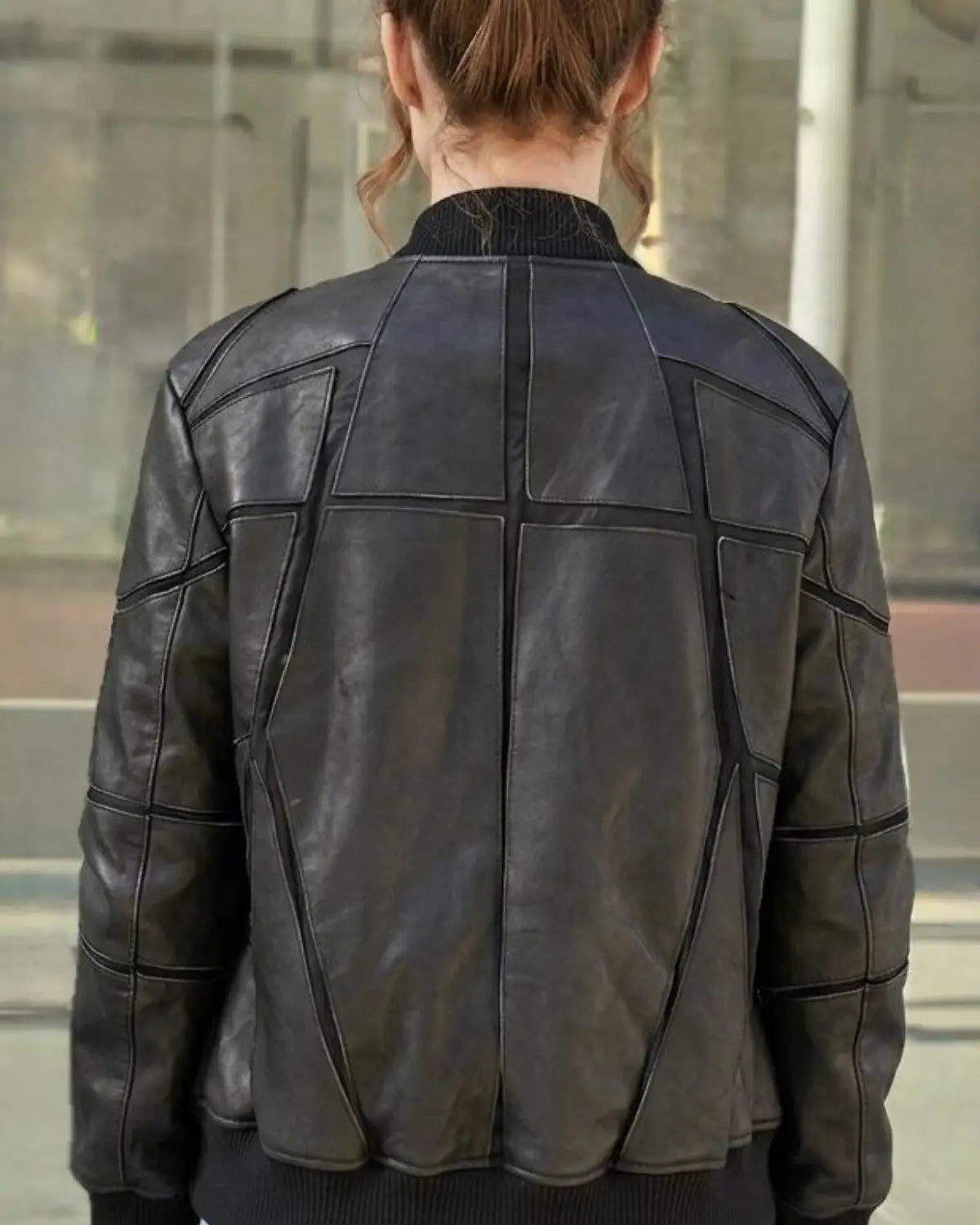 A woman wearing a black leather jacket with geometric paneling all designed exclusively by Vannamoda