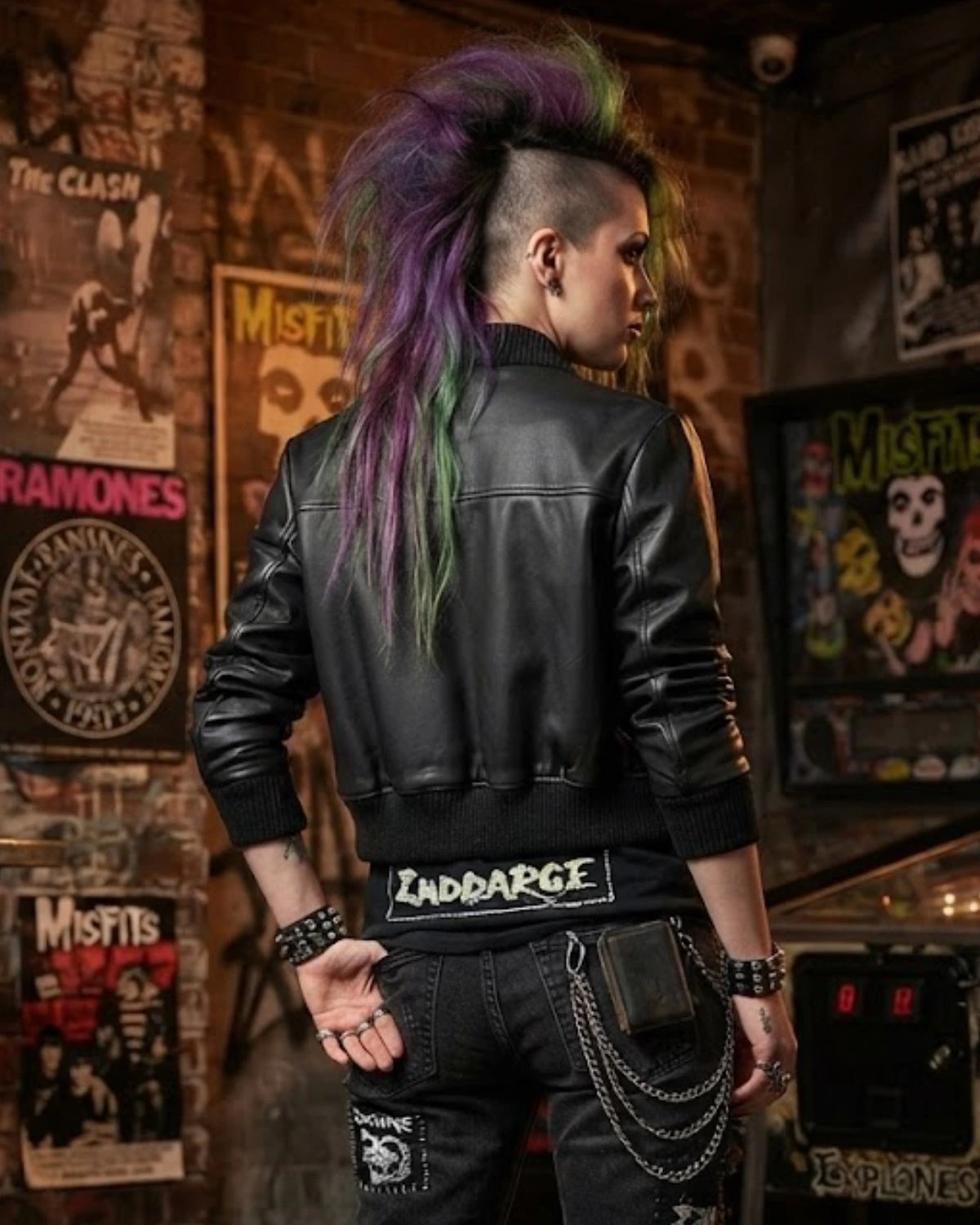 woman is wearing a black Lamb leather jacket with  layered necklaces, leather studded bracelet and a wallet chain looped in jeans all designed by Vannamoda NYC. 