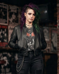 woman is wearing a black Lamb leather jacket with  layered necklaces, leather studded bracelet and a wallet chain looped in jeans all designed by Vannamoda NYC. 