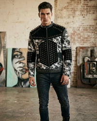 Man wearing a camouflage jacket with studded details in an urban setting.