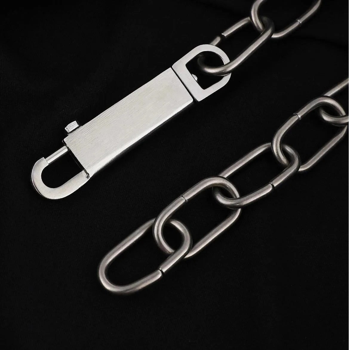 A close-up of a silver metal chain accessory with a rectangular clasp and interlocking oval links, Star Inverted Pentagram Chain Statement Necklace with big star