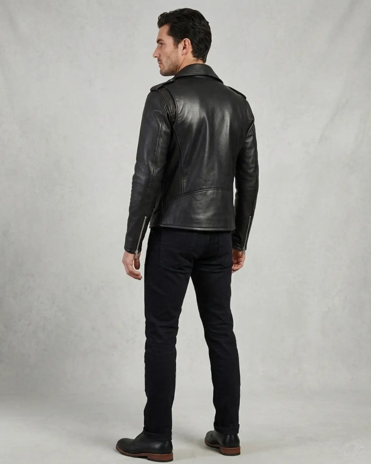 A man wearing a black leather biker jacket, black jeans,