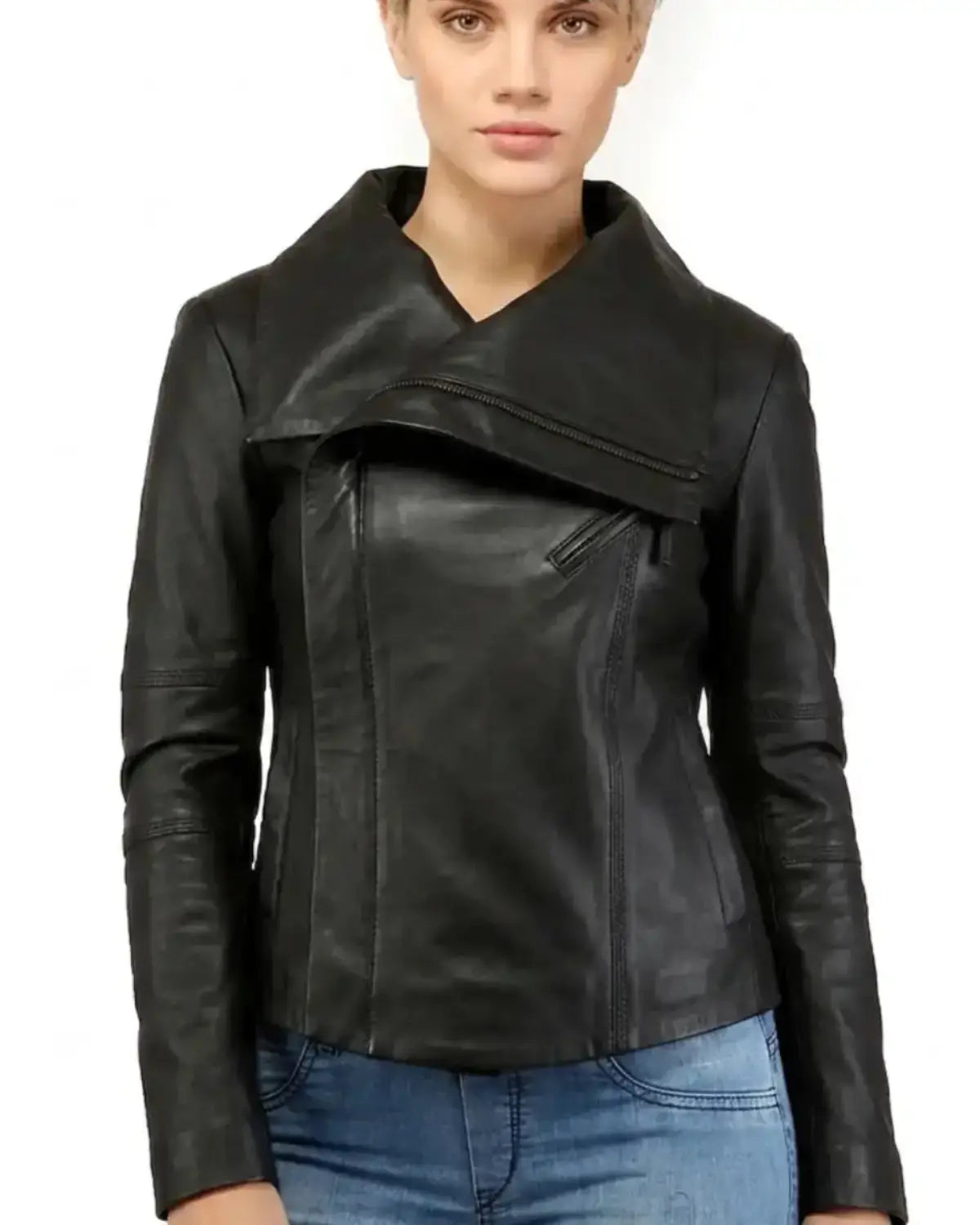 A woman wearing a black leather jacket with an asymmetrical wrap-style front and blue jeans, photographed against a plain white background.