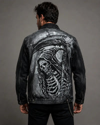 Hand-painted black acid wash denim jacket featuring a detailed grim reaper graphic on the back, shown on a male model