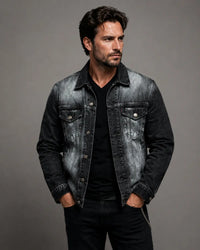 Front view of a man wearing a custom hand-painted black denim jacket and dark jeans in an alternative streetwear style