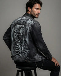 Hand-painted black acid wash denim jacket featuring a detailed grim reaper graphic on the back, shown on a male model