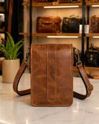 Brown crunch leather crossbody bag worn by female model