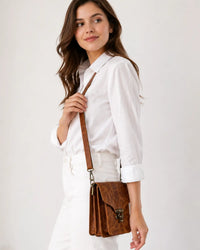 Brown crunch leather crossbody bag worn by female model